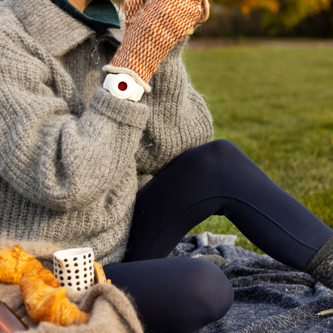 A woman in autumn wearing a red light therapy bracelet