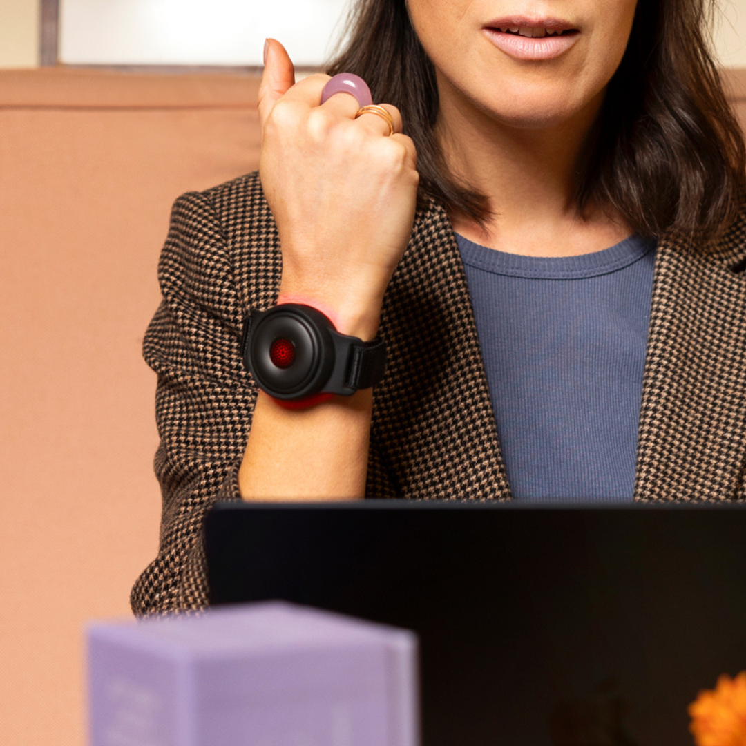 A woman working wearing a red light therapy bracelet